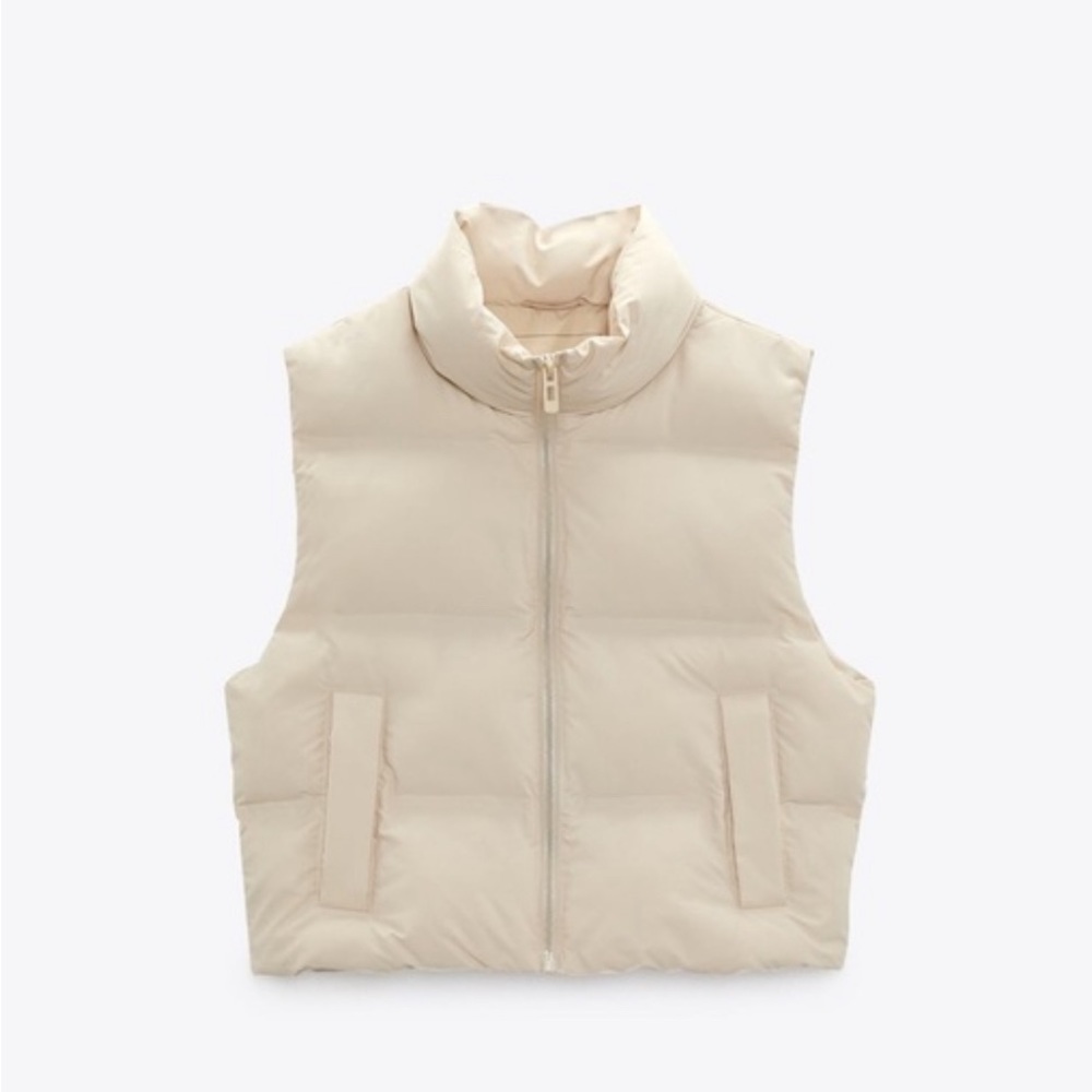 Cream high collar cropped vest. Front pockets with polar fleece interior.